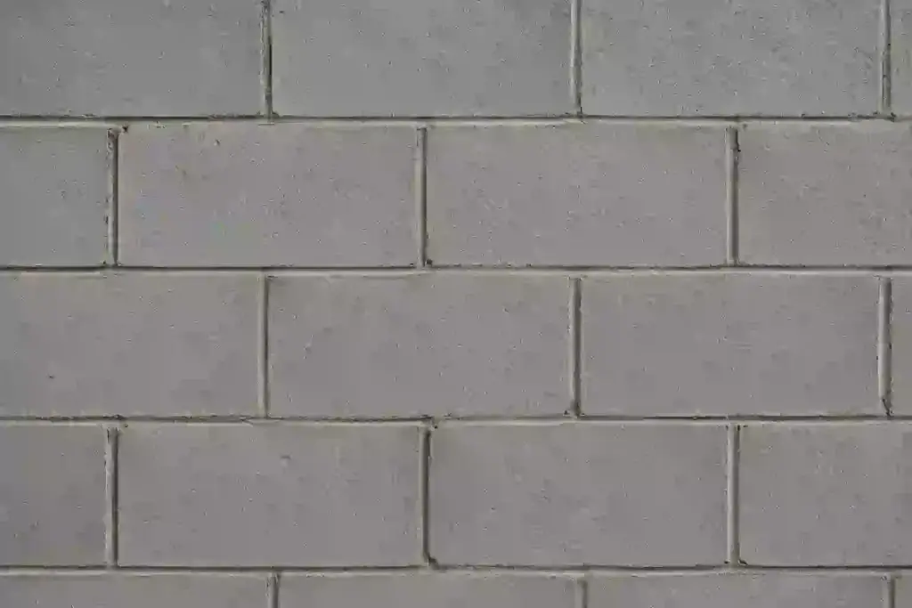 Close-up texture of a concrete block basement foundation wall with visible mortar joints and stacked masonry blocks.
