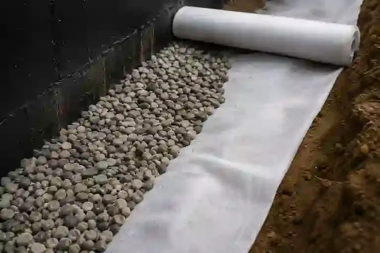 Washed stone and filter fabric installed for interior basement drainage performance.